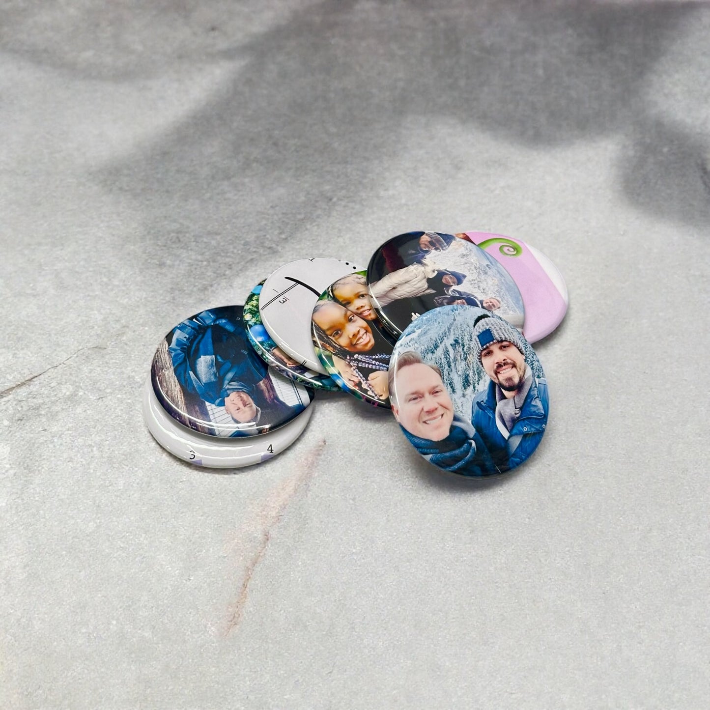 Personalized custom photo magnets displayed on a refrigerator door, featuring various family photos, travel snapshots, and pet pictures, each printed on round magnets with a glossy finish.