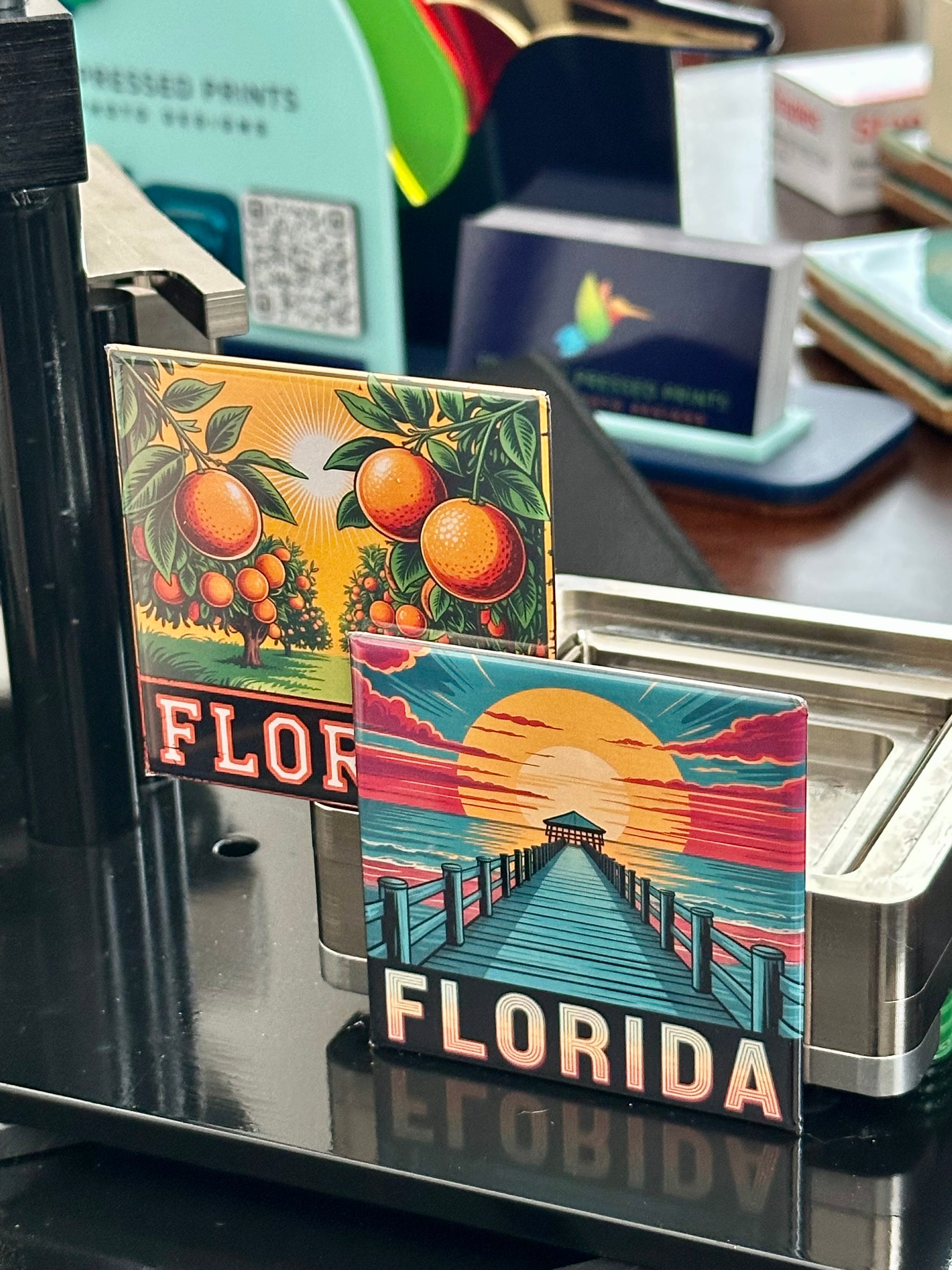 Two small decorative magnets with 'Florida' text and imagery on a stand.